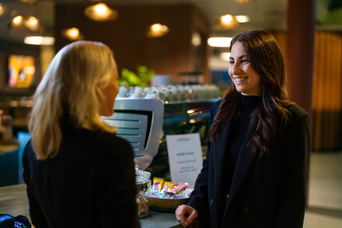 Smilende ansatt ved arbeidsplassen sin i et kommunalt kontor